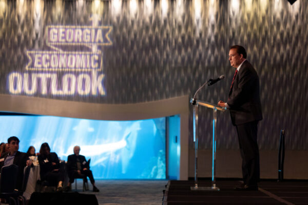 $8.4 Billion Economic Impact on Georgia. Speaker standing in front of 
