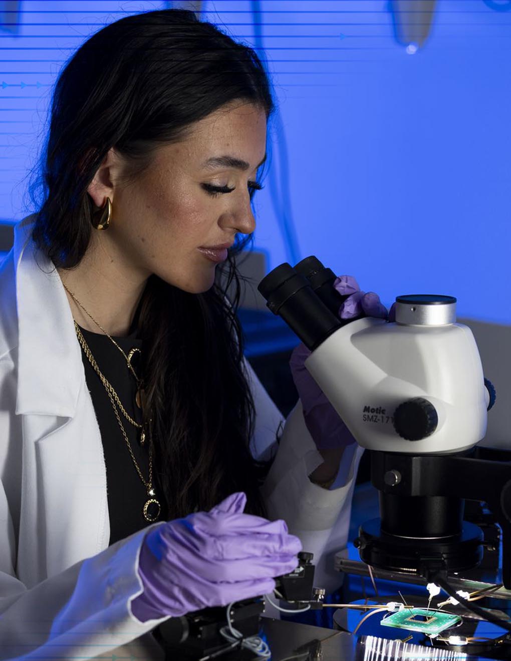 UGA graduate Ashley Galanti viewing a microchip through a microscope.