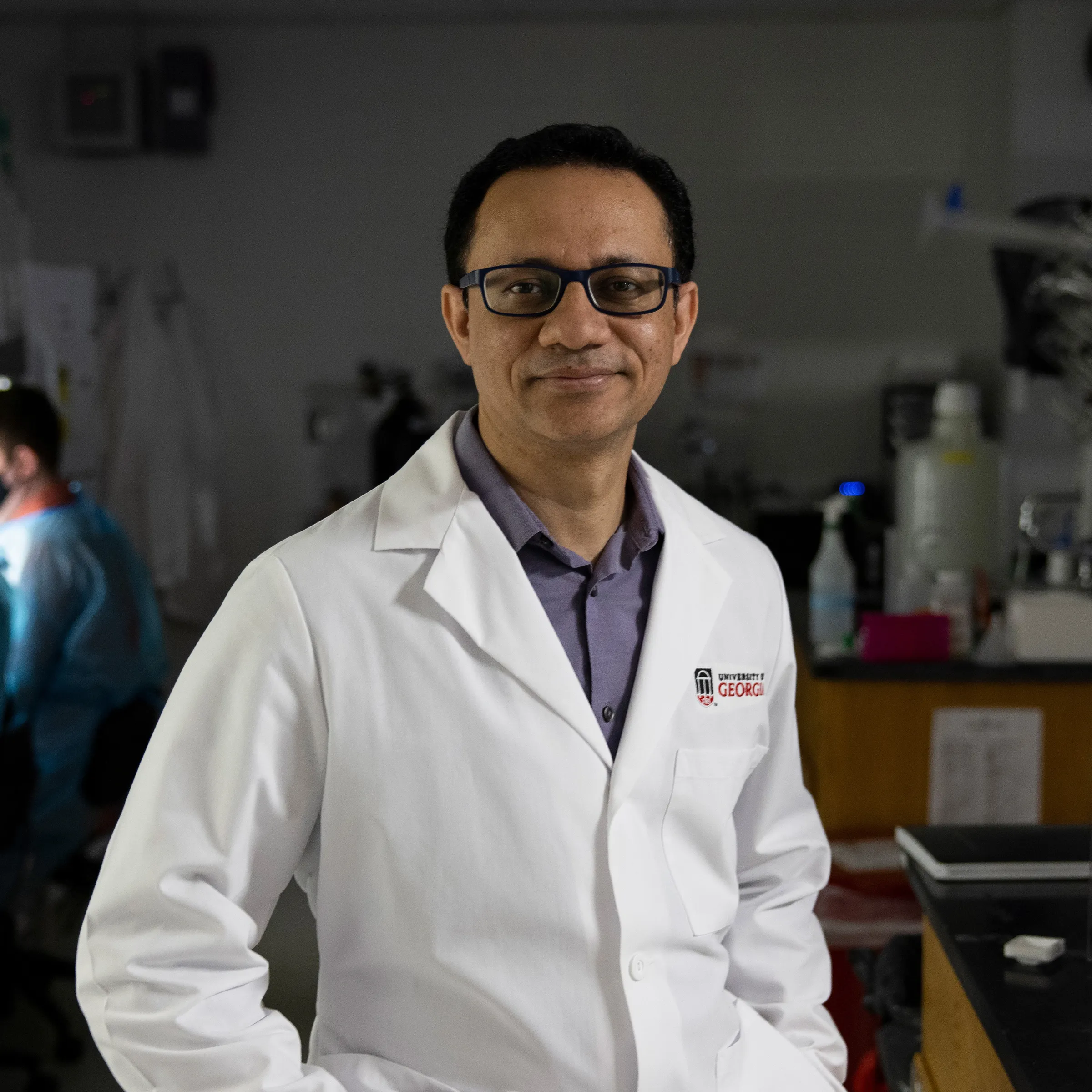 A closeup photo from the waist-up of Hitesh Handa in a white lab coat.