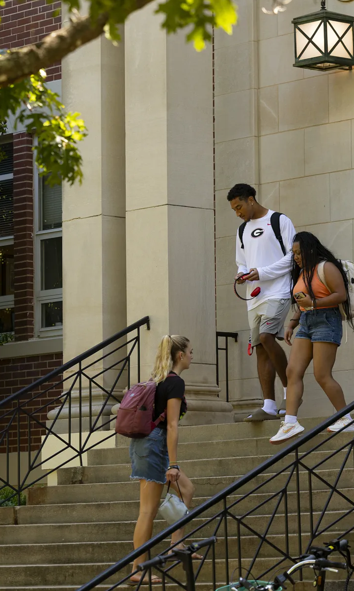 Students walk along the sidewalk and on the steps during a class change at the Warnell School of Forestry and Natural Resources Building I on south campus.