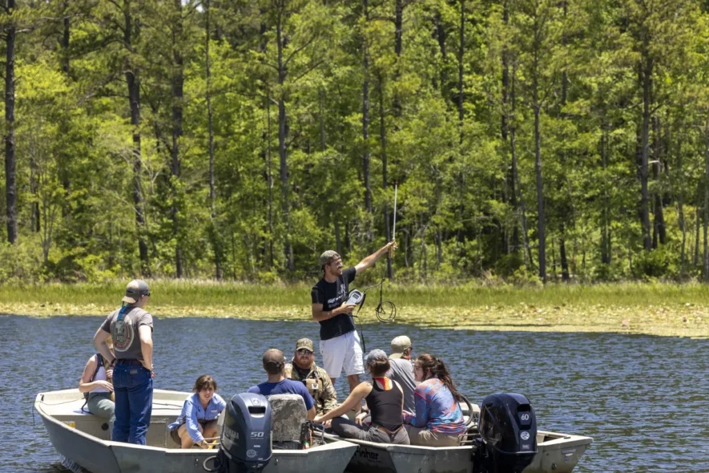 College students on a boat in a lake observe nature at the Savannah River Ecology Laboratory (SREL).